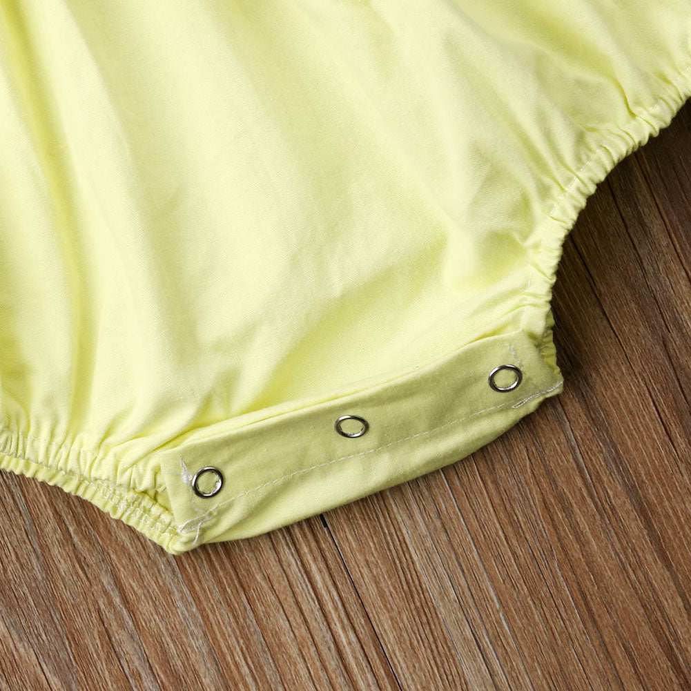 Close-up of snap buttons on the crotch of the yellow  Spanish baby clothing bubble romper for reborns and babies: reborn doll clothing