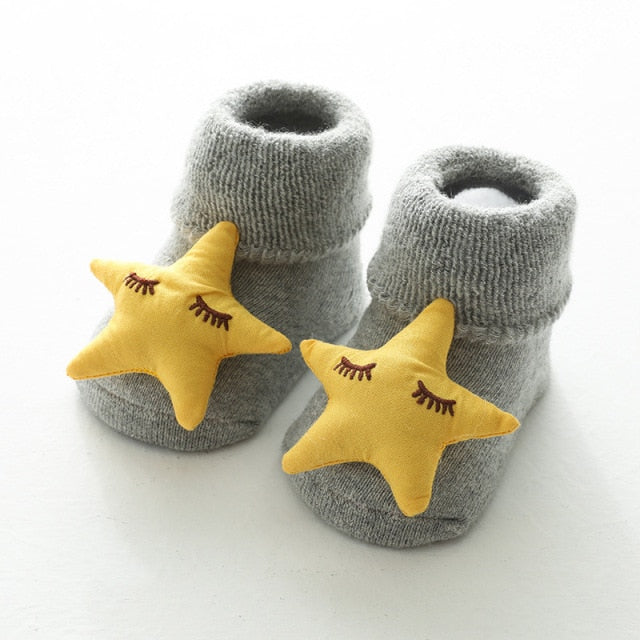 Grey reborn baby socks or cuddle baby socks with a stuffed yellow sleeping star on the toe.