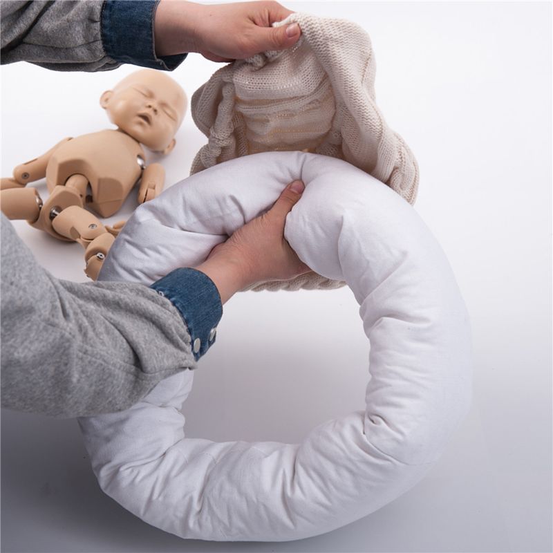 Cream/white posing pillow for reborn dolls or newborn photography with knit cover being put on.