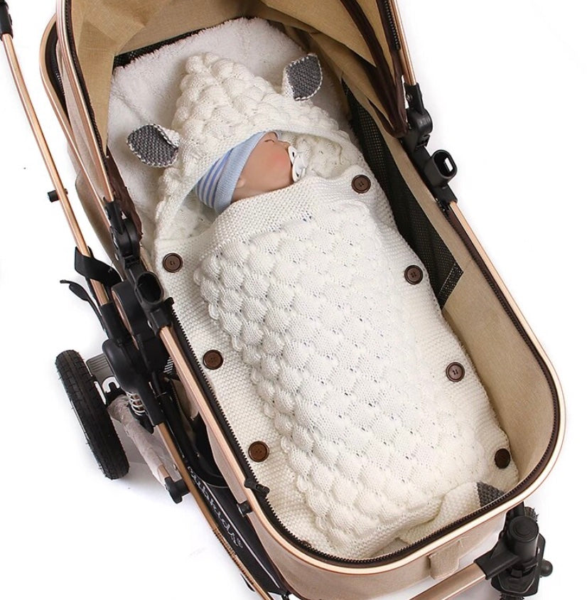 Reborn doll in a stroller in an ivory white Sleepy Little Fox Knitted Sleep Sacks for newborns, babies and reborn dolls. Envelope style sleeping bag with buttons, fox ears, and a fox tail. Size details.